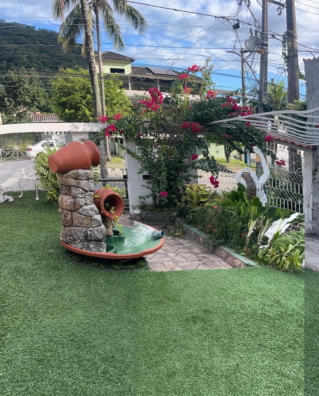 Jardim com fonte decorativa na Pousada Guimarães