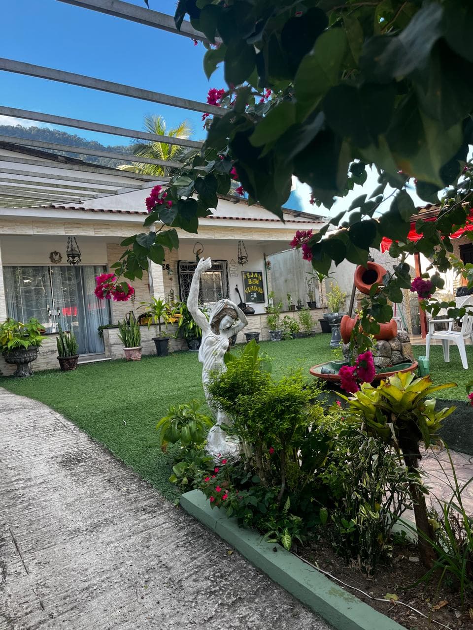 Caminho externo com jardim na Pousada Guimarães